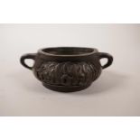 A Chinese bronze two handled censer with cursive script decoration, seal mark to base, 3" diameter