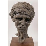 A composition bust of a curly haired boy, mounted on a wooden base, 13½" high