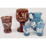 A Bohemian flash cut ruby glass goblet engraved with buildings and a stag, 7" high together with a