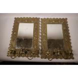 A pair of C19th brass framed pier glass mirrors with candle sconces, the frame pressed with a