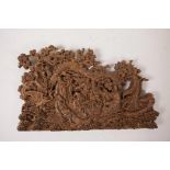 A Chinese carved sandalwood panel decorated with the eight immortals in a wooded landscape, 11" wide