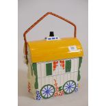 A ceramic biscuit barrel in the form of a gypsy's caravan, 11" high