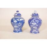 Two Chinese ceramic jars with blue and white decoration of prunus and cracked ice, both chipped