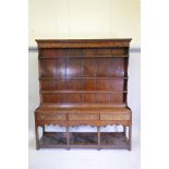 An C18th oak potboard dresser with an open Delft rack and three drawers, 71½" x 17½", 82½" high