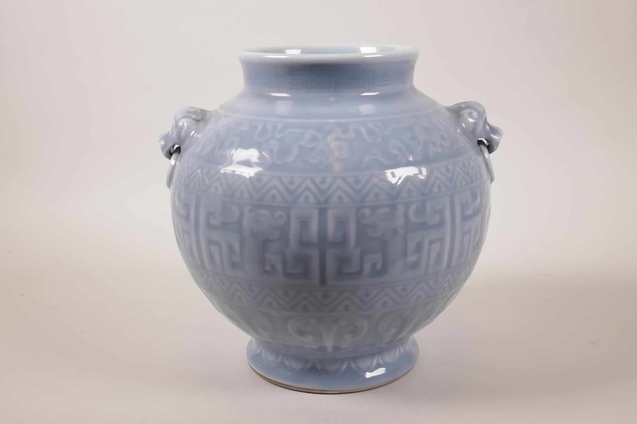 A Chinese powder blue glazed vase with two mask handles and archaic style decoration, seal mark to