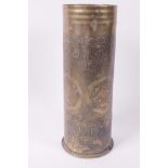 Trench Art, a brass shell case engraved with panels of figures, Persian patterns and script,