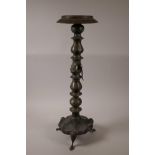 A Middle Eastern three section brass lamp stand, with engraved decoration, raised on tripod