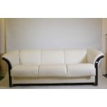 An Ekornes 'Stressless' Manhattan three seater sofa in cream leather, with dark stained show-wood,