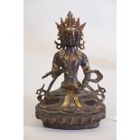 A patinated bronze figure of Buddha, with polished highlights, inset with red and blue beads, 11"