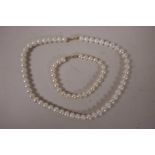 A pearl necklace with gold (750mk) clasp, 16" long, together with a matching bracelet