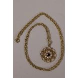 A delicate 9ct gold filigree pendant set with garnet and seed pearls on an 18ct gold double link