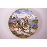 A majolica wall plate with painted decoration of St. George slaying the dragon, 11" diameter, A/F