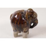 A treacle glazed pottery specimen vase in the form of an elephant, 4½" high
