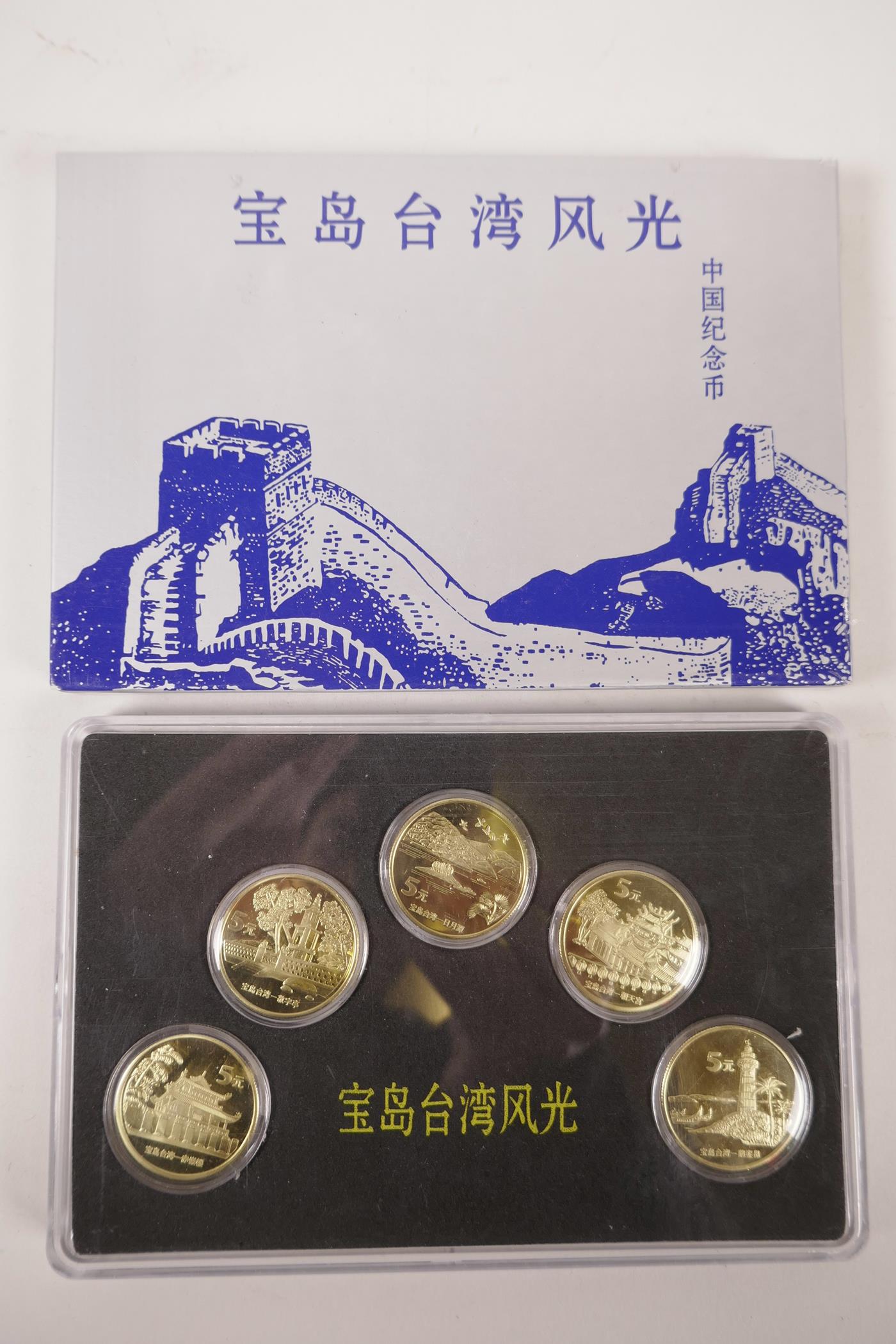 A cased collection of facsimile (replica) Chinese gilt metal coins commemorating important monuments