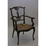 A Victorian inlaid mahogany elbow chair with shaped arms and pierced and shaped back, raised on