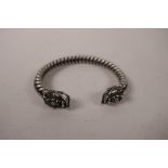 A Chinese white metal rope twist bangle with dragon head decoration to ends, 3" wide