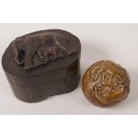 An African carved wood trinket box, the swivel lid decorated with an elephant and calf, 3" high,