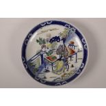 A Chinese polychrome porcelain dish with enamel decoration of women and a child in a garden, 9"
