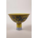 A Chinese yellow ground porcelain stem bowl with blue and white decoration of a dragon chasing the