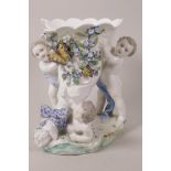 A C19th porcelain cornucopia, the large flower encrusted shell trumpet supported by three cherubs,