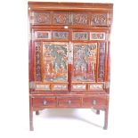 A Chinese lacquered cabinet in two sections, the upper with two over two cupboards on a base of