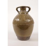 A small Chinese olive glazed pottery jar with two handles, incised character mark to side, 5" high