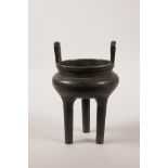 A Chinese bronze two handled censer raised on three tall supports, 7" high, character marks to side