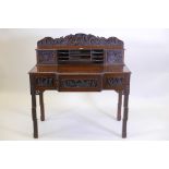 A Chinese padauk wood desk, the upper section with two cupboards flanking open pigeonholes, the base