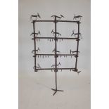 An antique wrought iron candle holder with stylised deer and stag decoration, 46" high