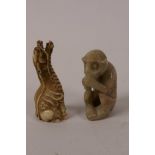 A small Oriental carved bone figurine of a mythical beast, 2¼" high, and a carved soapstone figurine