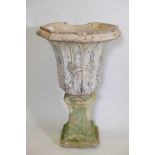 A C19th terracotta garden urn, cast with flowers, 13" high, on an associated cast composite