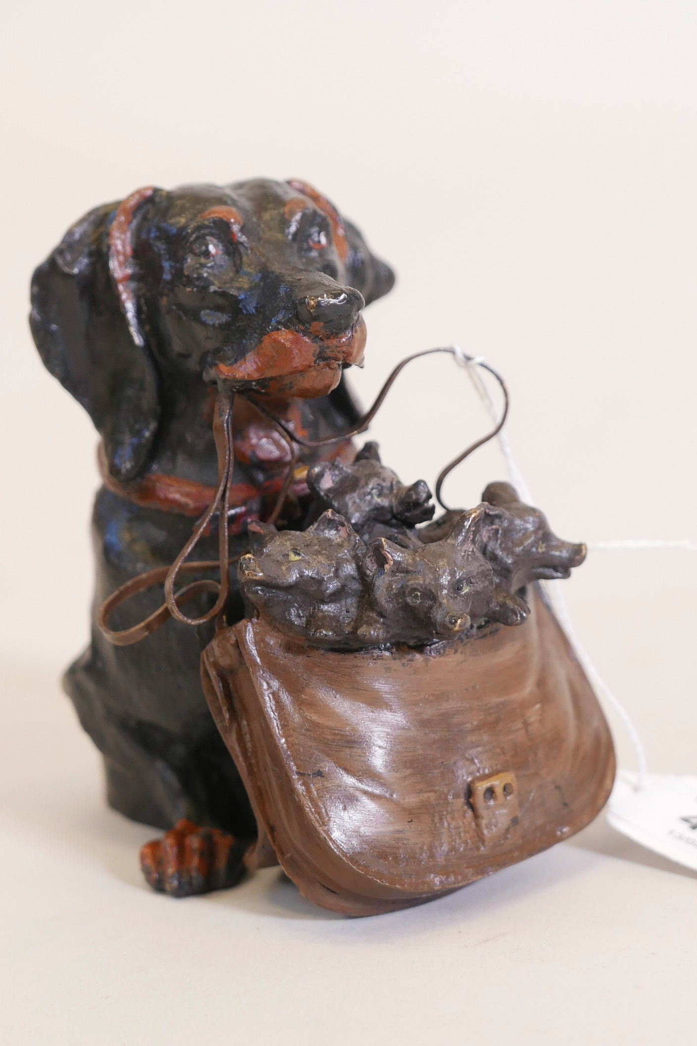 A cold painted bronze inkwell in the form of a dachshund with a satchel of puppies, 4½" high