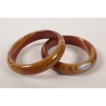 A pair of Chinese red agate bangles, 3" diameter