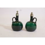 A pair of green glass decanters with white metal mounts and stoppers, 9" high