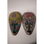 A pair of carved wood, brightly painted wall masks, 12" long