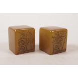 A pair of Chinese amber soapstone seals with engraved landscape and character inscription decoration