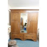 A late C19th oak wardrobe with Art Nouveau style inlaid decoration, the two cupboards flanking a