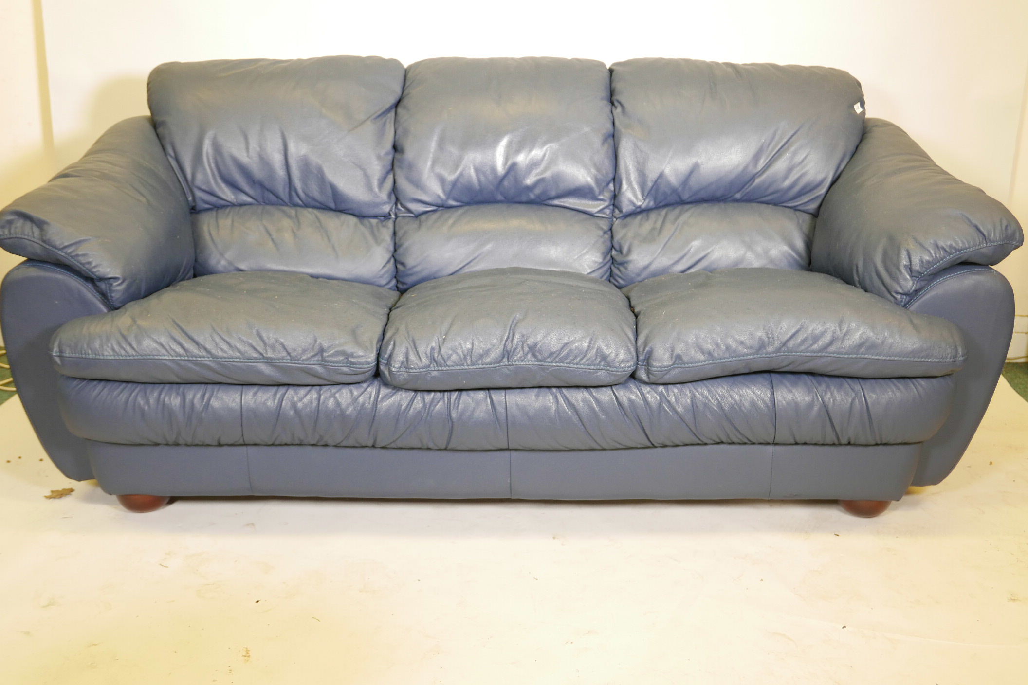 A blue leather three seater sofa, 84" wide