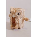 A carved bone tape measure in the form of an owl, 2" high