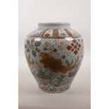 A Chinese wucai porcelain jar decorated with carp in a lotus pond, 6 character mark to base, 10"