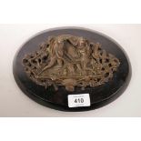 A copper plaque depicting soldiers playing dice, mounted on a wood plaque, 9" wide