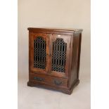 An Indian hardwood cabinet with two doors, with open grill doors over one long base drawer, 43"