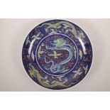 A Chinese polychrome porcelain dish with dragon decoration on a blue ground, 6 character mark to