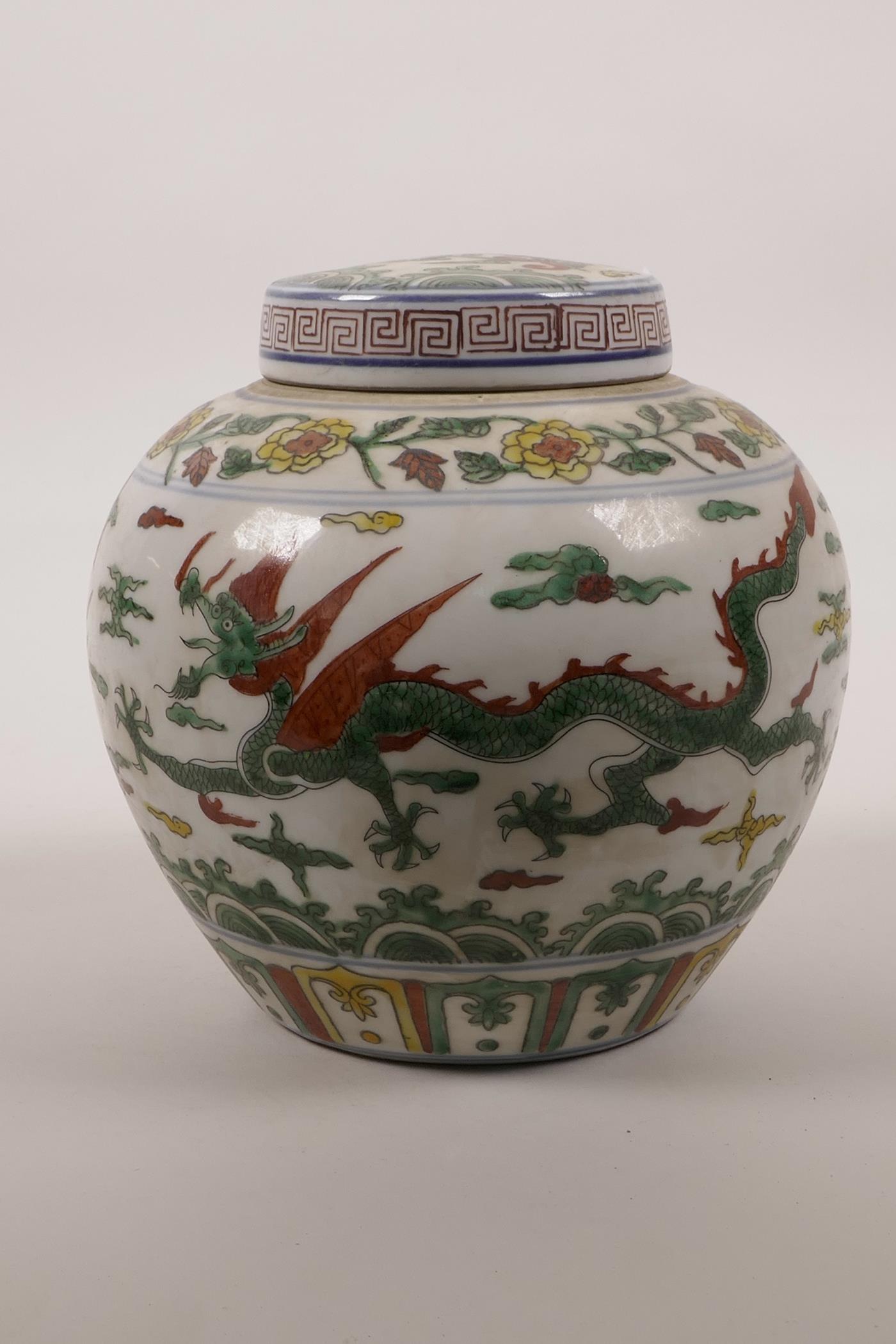 A Chinese wucai porcelain jar and cover decorated with dragons and phoenix in flight, 6 character