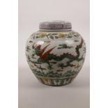 A Chinese wucai porcelain jar and cover decorated with dragons and phoenix in flight, 6 character