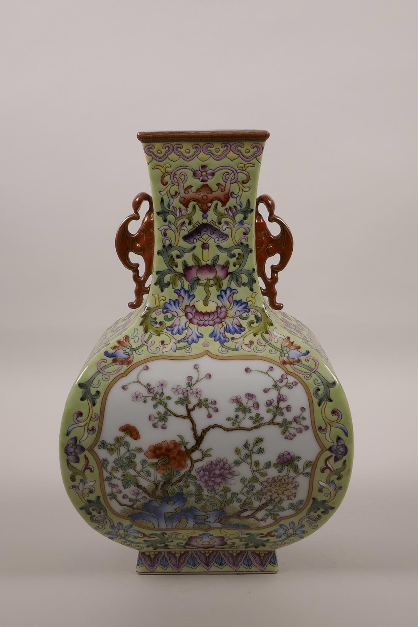 A Chinese polychrome enamelled porcelain vase with two bat shaped handles and decorative panels