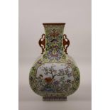 A Chinese polychrome enamelled porcelain vase with two bat shaped handles and decorative panels