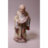 A Chinese porcelain figure of a robed sage reading from a scroll,12" high