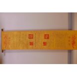 A Chinese gilt silk scroll with all over inscriptions, 13" x 56"
