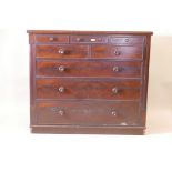 A Victorian figured mahogany chest of three drawers over five with original wood handles inset